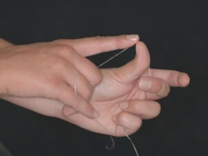 flossing - Then make a fist with the left hand and pull the floss back like a bow and arrow.