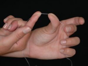 Reach out with your right index finger and touch the thumb – you may need to wrap the floss more so the hands are close together.